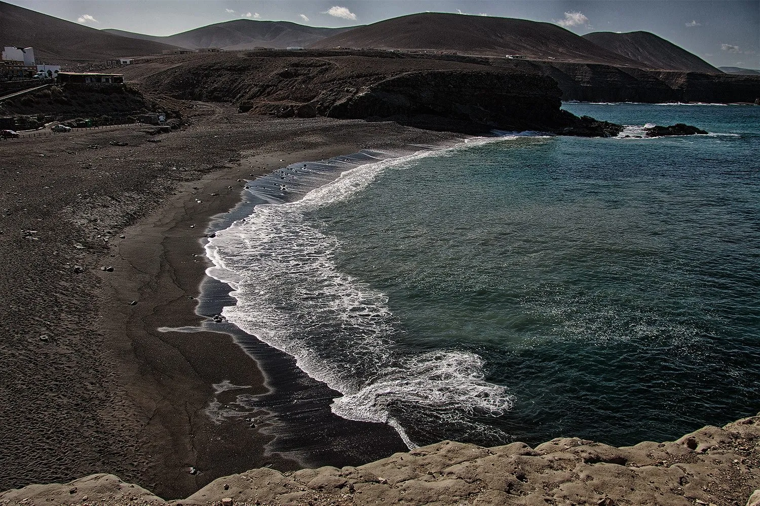 The dramatic black volcanic sand of Playa de Ajuy on the west coast of Fuerteventura