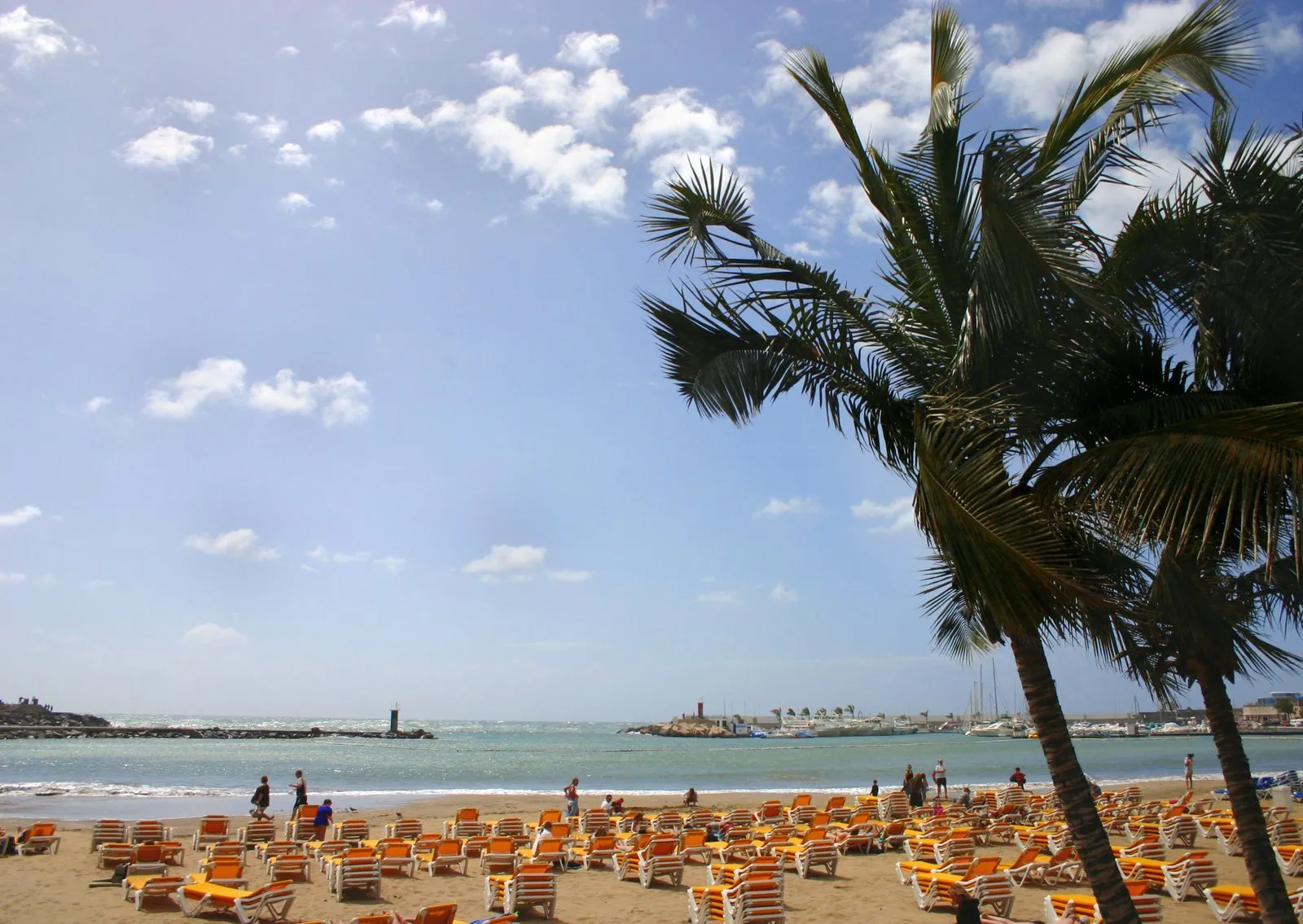 The golden sands and sheltered bay of Playa de Puerto Rico on southern Gran Canaria