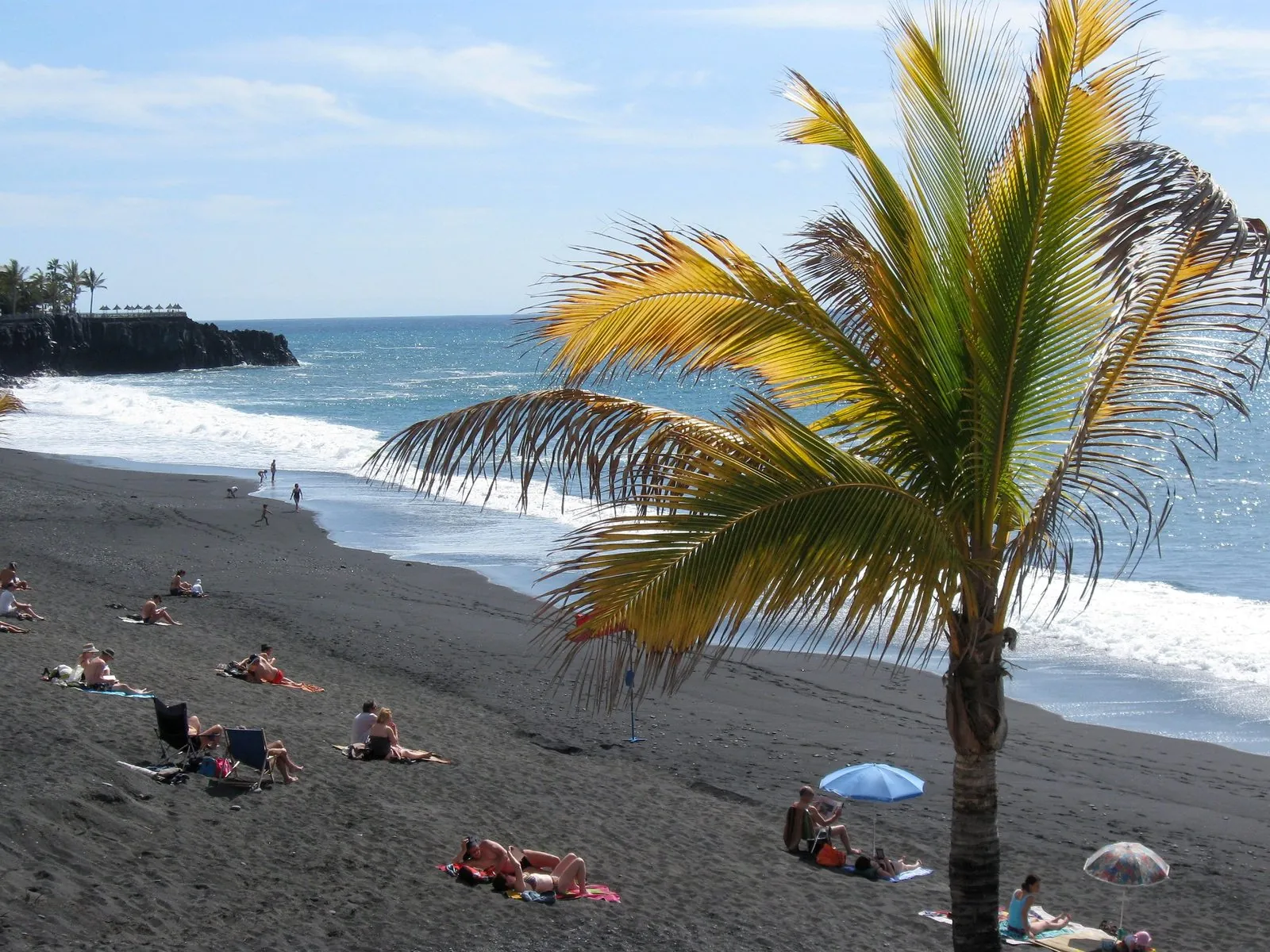 Dark volcanic sand and sunbeds at Puerto Naos, La Palma