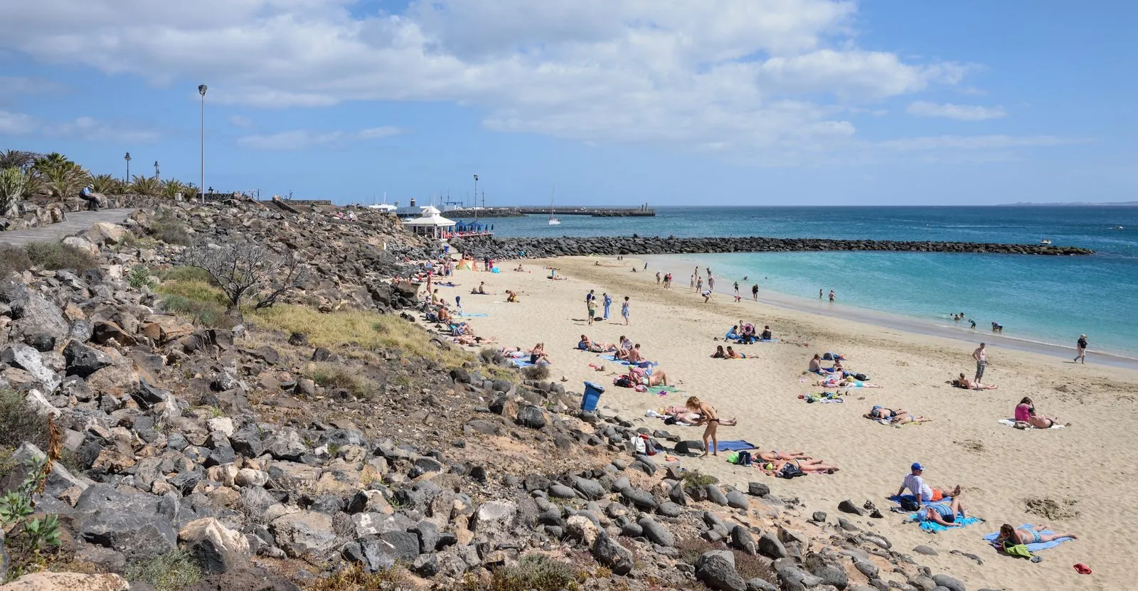 The sandy town beach of Playa Blanca curving toward its marina in southern Lanzarote