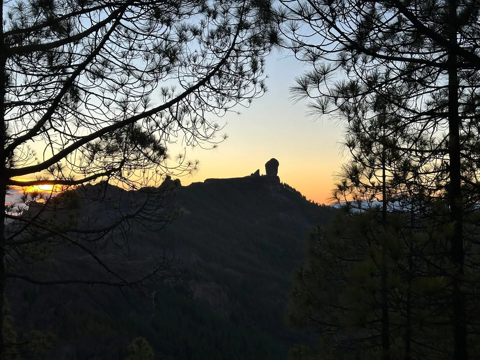 Hikers on the highland trail to the Roque Nublo rock monolith in the mountains of Gran Canaria