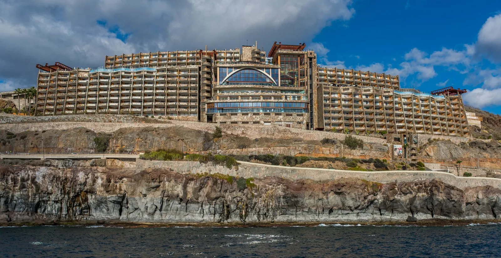 The sheltered resort bay and beach of Puerto Rico set among the hills of southern Gran Canaria