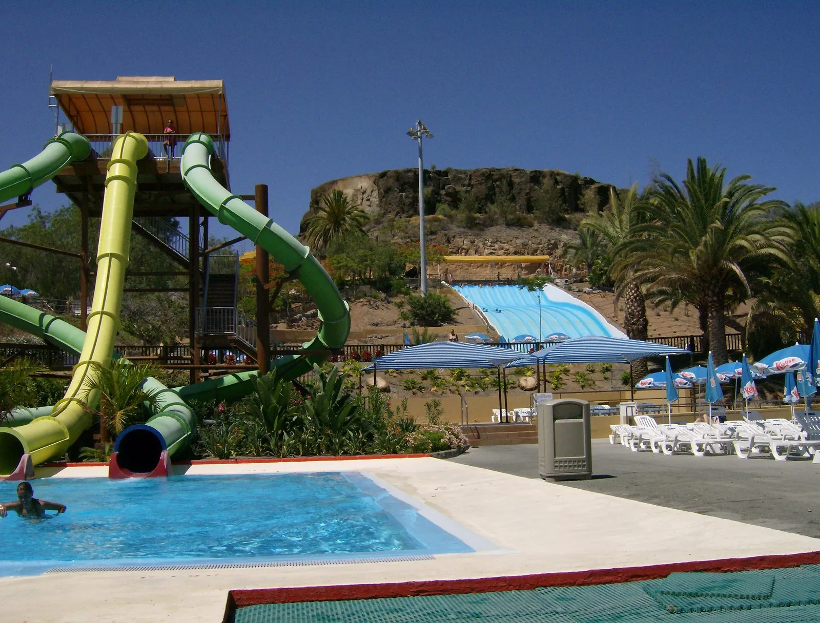 Green water slides, pools and palm trees at the Aqualand Maspalomas water park in southern Gran Canaria