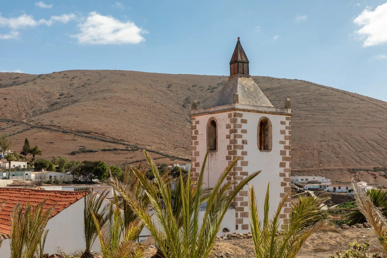 The stone bell tower of the Iglesia de Santa Maria rising above the village of Betancuria, Fuerteventura